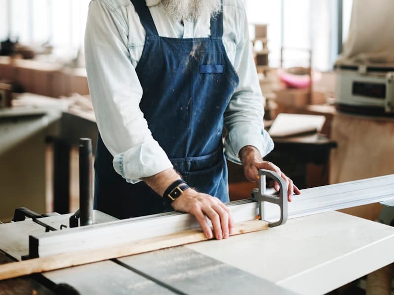 Craftsman in apron working at a woodworking bench